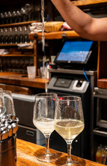 Pouring of txakoli or chacolí slightly sparkling very dry white wine produced in Spanish Basque Country in typical pinchos bar in old part of San Sebastian or Donostia, Spain