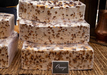 Fresh dessert traditional nougat with chocolate, nuts and fruits on local farmers market in Montellimar, France