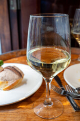 Glass of txakoli or chacolí slightly sparkling very dry white wine produced in Spanish Basque Country in typical pinchos bar in old part of San Sebastian or Donostia, Spain