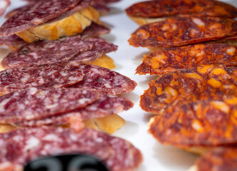 Typical snack of Basque Country, pinchos or pinxtos skewers with small pieces of bread, sea food, eggs, cheese, jamon served in bar in San-Sebastian or Bilbao, Spain, close up