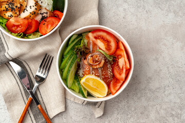 Beautiful composition with poke bowls on gray background with napkin