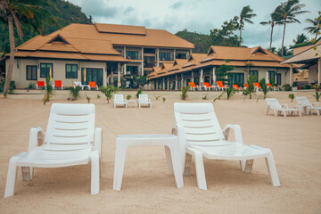 A row of beach chairs on the sand of a tropical beach. Relaxation, vacation, and tropical...