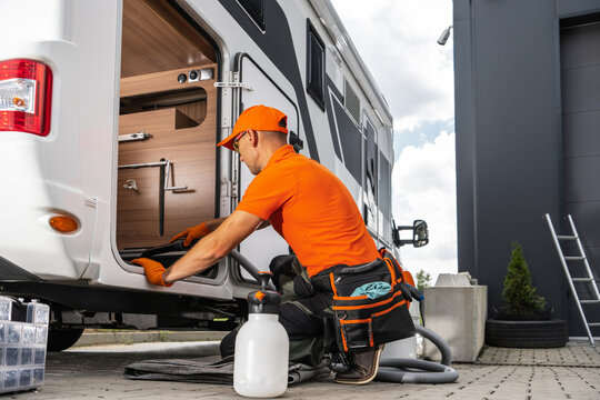 Camper Rentals Worker Cleaning RV Interior With Vacuum