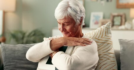 Senior, woman and hugging photograph on couch for thinking, nostalgia and remember memory of history or past. Elderly person, home and thoughts on sofa with picture, missing and mourning with grief.