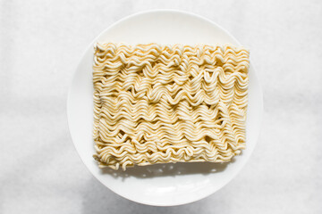 Overhead view of ramen noodles, top view of dry instant noodles on a white plate