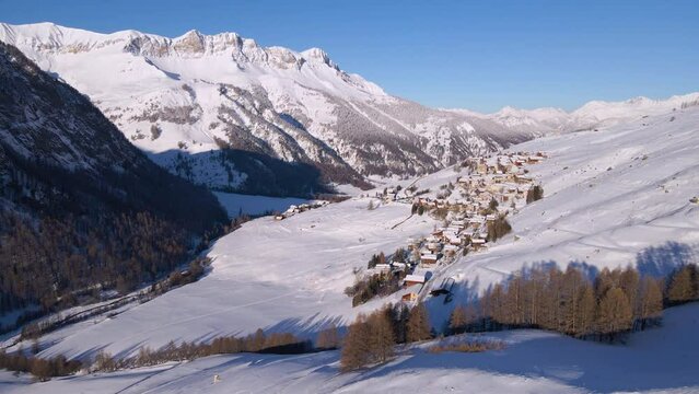 Aerial view of snowy peaks and village of Saint-Veran, the third highest village in Europe (designated Most Beautiful Villages of France). Queyras Regional Natural Park, Hautes-Alpes, Alps, France