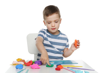 Little boy sculpting with play dough at table on white background