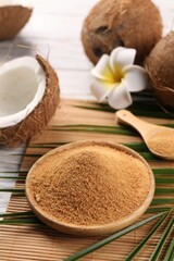 Coconut sugar, palm leaves, fruits and bamboo mat on wooden rustic table, closeup