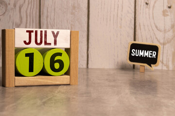 July 16 calendar date text on wooden blocks with blurred background park