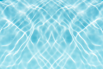 Blue water with ripples on the surface. Defocus blurred transparent blue colored clear calm water surface texture with splashes and bubbles. Water waves with shining pattern texture background.
