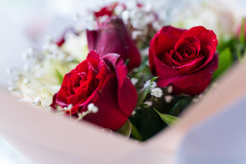 A bouquet of red roses with white flowers. The flowers are fresh and vibrant, giving off a sense of love and romance