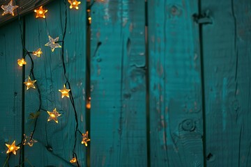Close-up of star-shaped lights on a fence on teal background