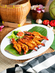 Udang Bakar Jimbaran, grilled prawn with jimbaran sauce. Balinese food with traditional props and indonesian spices