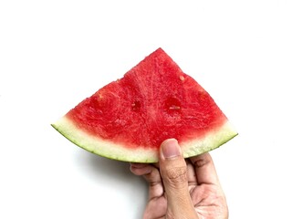Adult Asian man's hand with brown skin holding slice of watermelon isolated on white background
