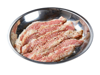 Top view of fresh pork marinated with black pepper and white sesame served served on a stainless steel tray isolated on white background.