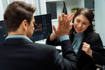 Successful in two business traders making hands high five with fist up to earn highest profit stock...
