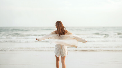 Rear view - Happy carefree young asian woman with freedom on the sea beach, Lady girl enjoying beach holiday, Summer beach vacation concept