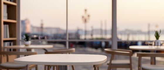 A table in a minimalist coffee shop or restaurant seating area by a window with a city view.