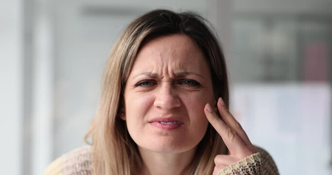 Confused woman squints to see suffering from poor eyesight