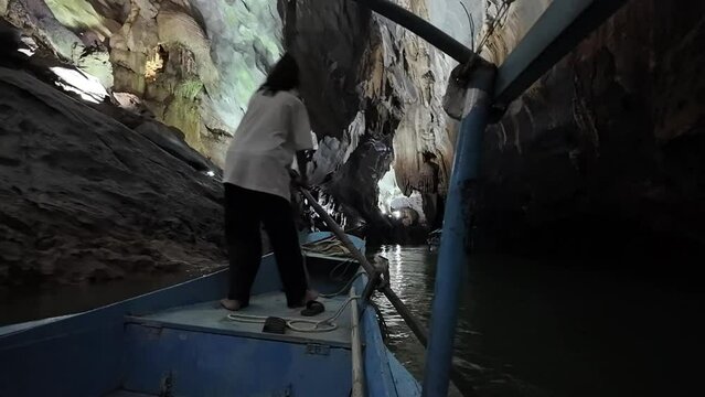 Boatman rowing boat move inside Phong Nha Ke Bang cave at National park, attraction formation geological of limestone mountain, underground destination Vietnamese, Quang Binh
