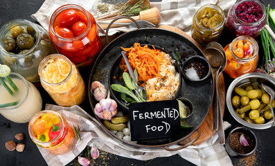 Fermented products on a dark background. Pickled vegetables in jars