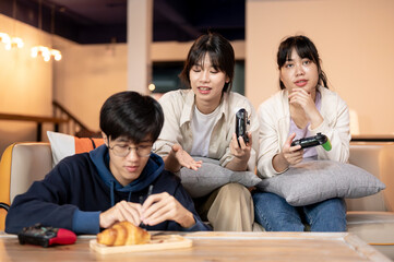 A group of cheerful Asian friends are having a fun time together at home, playing video games.