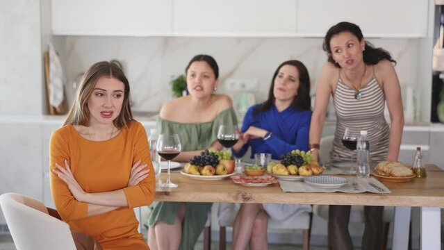 Female friends during family quarrel accuse Caucasian woman, prove her wrong. Girl indifferently turned away from grumpy people, neglects swearing and family quarrel