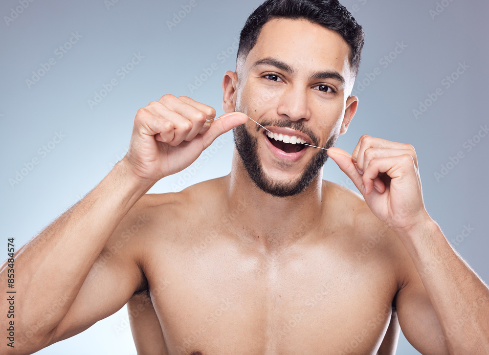 Wall mural Man, portrait and flossing teeth in studio for oral hygiene, mouth cleaning and morning routine for tooth care. Dental, person and thread for fresh breath, plaque and healthy gyms on gray background