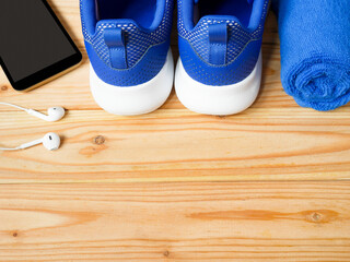Sneakers, mobile phone, earphones and towel