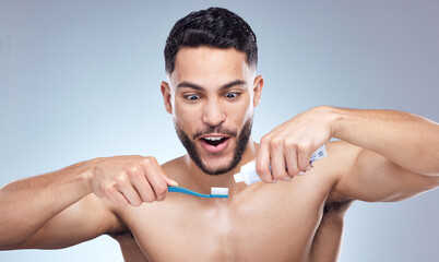 Man, toothbrush and surprised with toothpaste in studio for oral hygiene, mouth cleaning and morning routine. Dental, person and brushing teeth for fresh breath and healthy gums on gray background