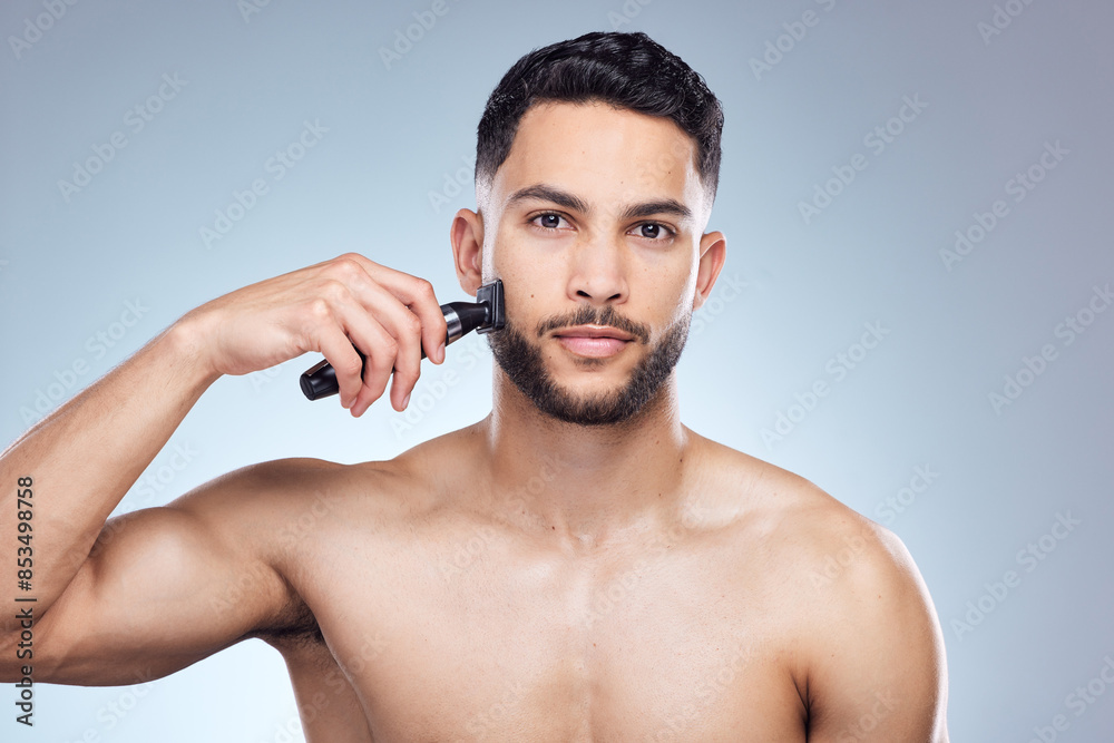 Wall mural Man, portrait and hair removal with shaver in studio, facial grooming and wellness or trimmer on background. Cosmetic, cleaning razor and morning routine with model, hygiene and dermatology skincare