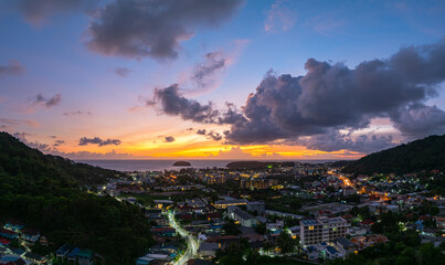 Aerial view Clouds obscure the beautiful sky as the sun sets. The lights along the beach begin to turn on as dusk approaches.There are many buildings, resorts, and hotels that accommodate tourists.