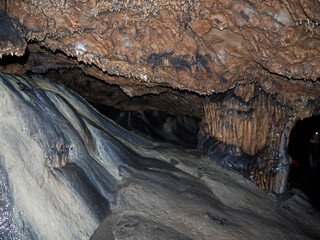 Hiking Inside the Dark cave environment with mineral deposits on the floor and walls