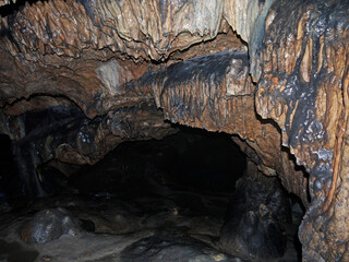 Hiking Inside the Dark cave environment with mineral deposits on the floor and walls