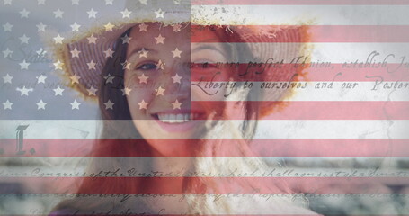 Constitution text and american flag against portrait of caucasian woman smiling in background