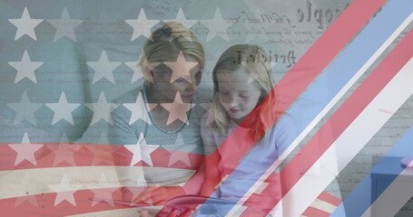 Naklejka premium American flag pattern and constitution text against caucasian mother and daughter reading a book