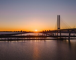A beautiful sunset view of a modern cable-stayed bridge over a calm river