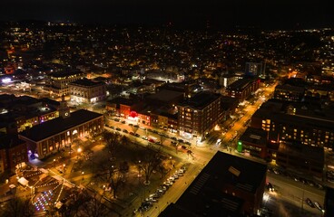 Aerial night view of a cityscape with illuminated buildings and streets