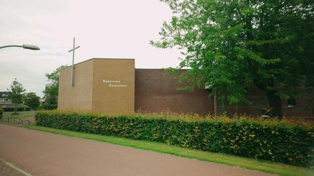 Footage of the brickstone square Baptisten Gemeente Protestant church in Lelystad, showcasing its unique architecture and surrounding area. Location: Lelystad, Netherlands