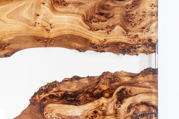 Live edge elm burl slab table top with central epoxy resin river on white background, combining...