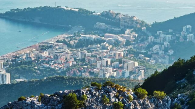 Telephoto drone shot of the Bečići city from the mountains, in sunny Montenegro