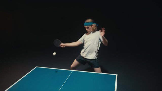 Man with long blond hair playing ping pong