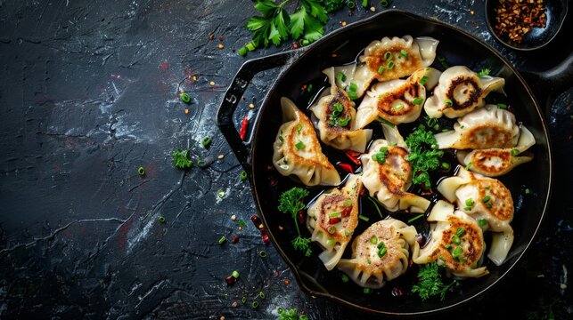 Delicious gedza dumplings in a pan with soy sauce. On dark rustic background