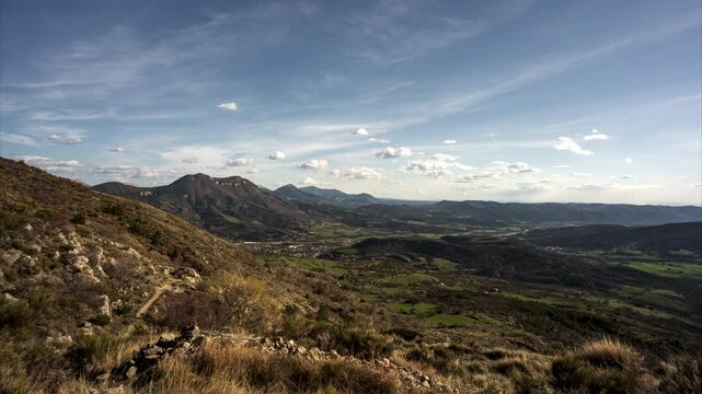Timelapse of ush valley with mountains in the background under the clear sky