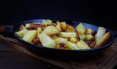 Roasted potatoes. Potatoes fried in butter in a cast iron frying pan.
