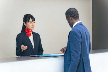 外国人訪問者を接客する女性スタッフ