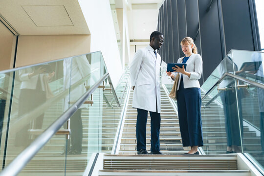 A group of multinational businessman and engineer in white coats having a conversation in the lobby