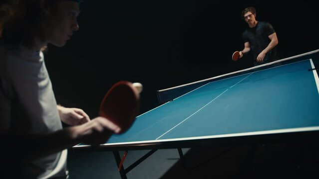 Dark room and ping pong players in a match