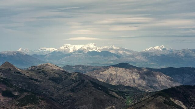 Timelapse of Des Monges mountain as snowy peaks during sunset or sunrise. Majestic snowy terrain in alpine alps with sky and clouds in time lapse as natural scenery. Snowy peaks and landscapes France