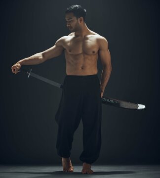 Asian man, ninja and samurai sword in studio for training, exercise and fitness or martial arts. Dojo, wellness and blade with warrior by black background for karate, sport and aikido in Japan